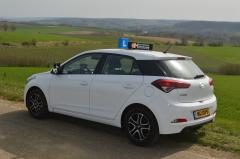 De lesauto van opzij, met het L-bordje op het dak